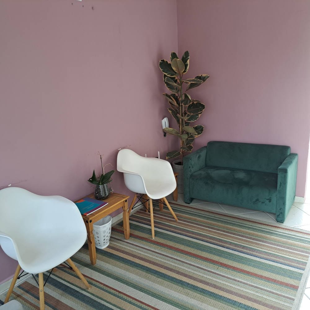 Sala de espera com poltronas e sofá em tons neutros do consultório de psicanálise em Curitiba de Marcelo Araldi, no Alto da XV.
